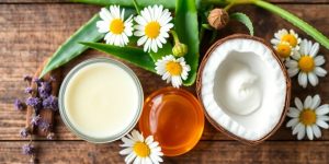 Natural ingredients for soothing irritated skin on wooden surface.